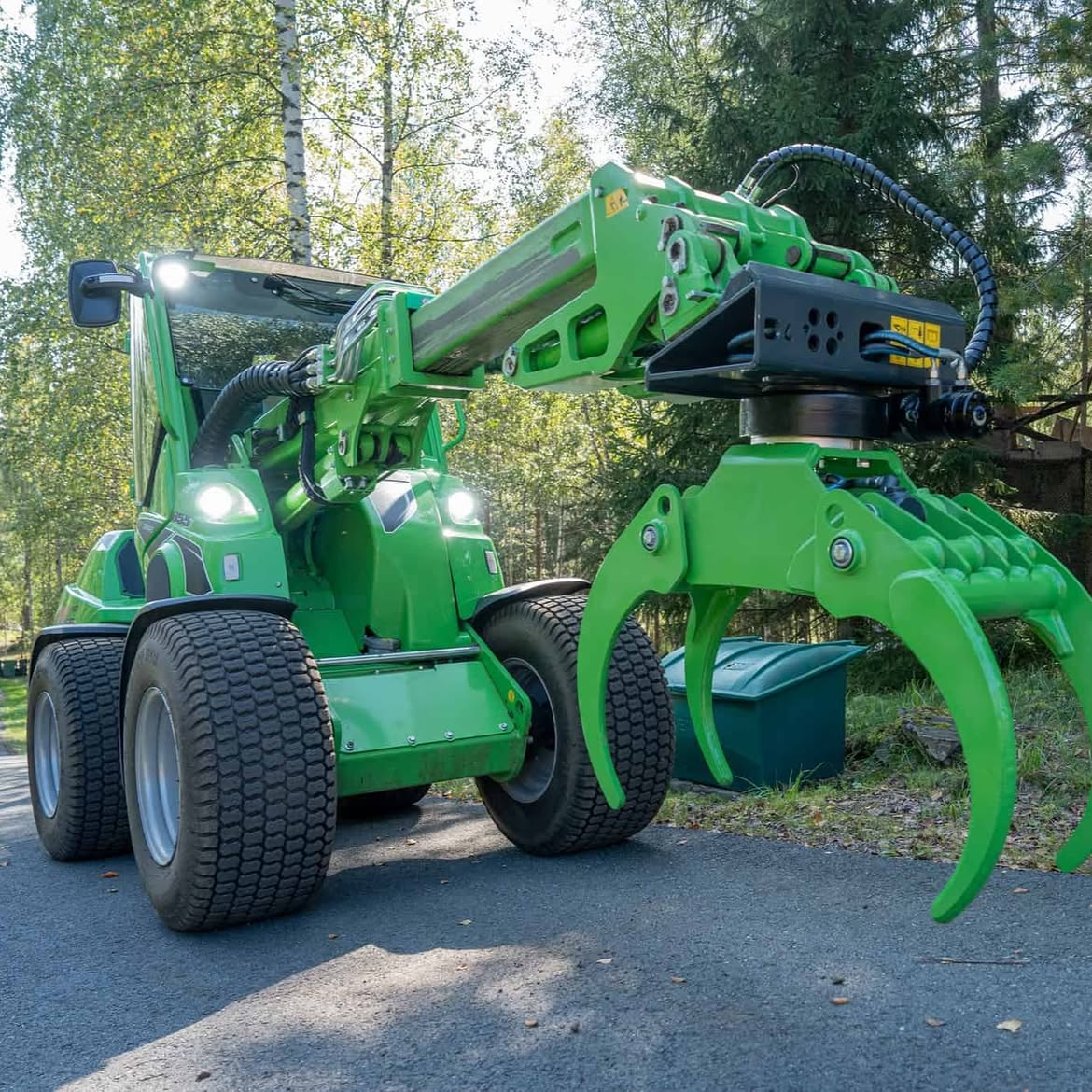 A compact green Avant loader fitted with a grapple attachment
